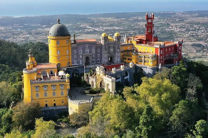 Aerial view of Pena Palace on its forested hilltop with the plain stretching away behind